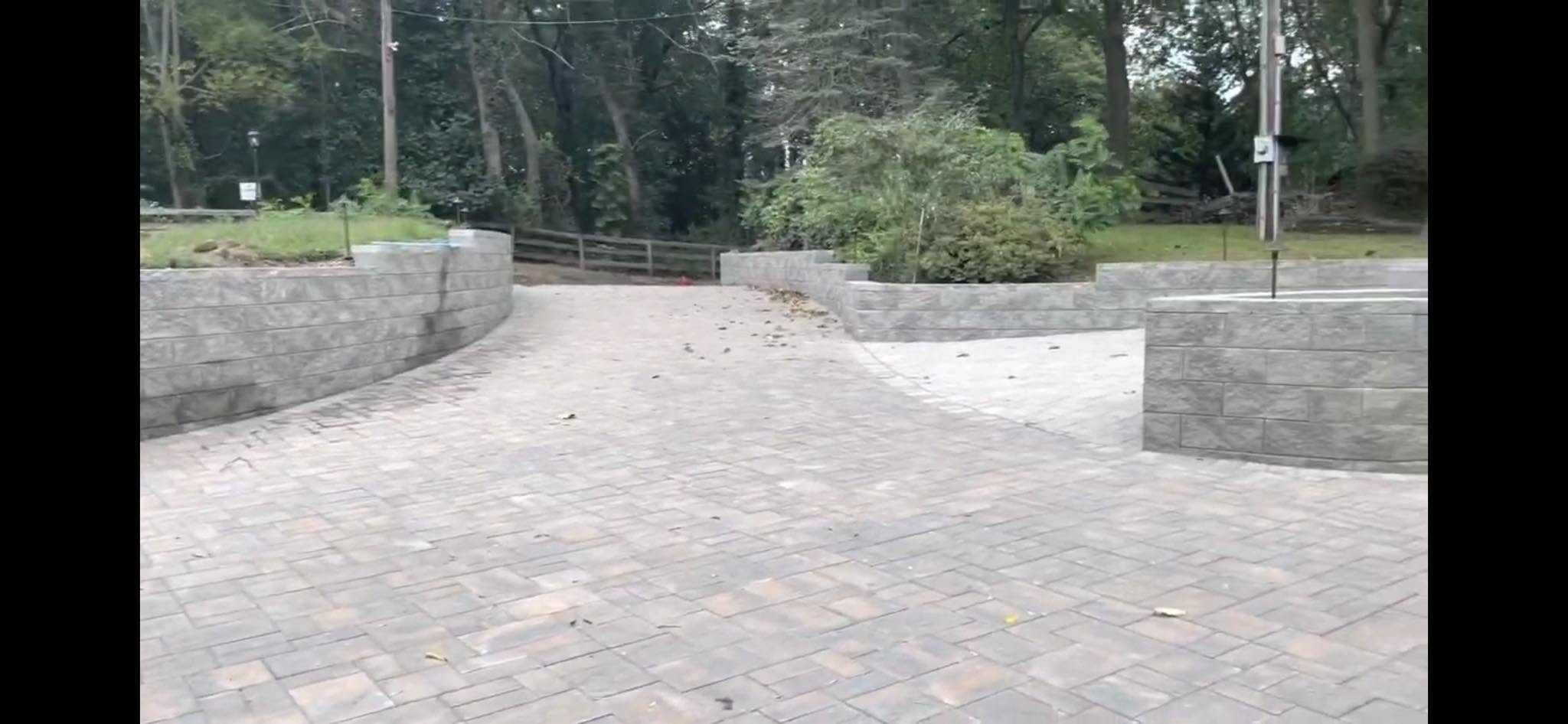Interlocking paver driveway with multi-tier textured stone retaining walls
